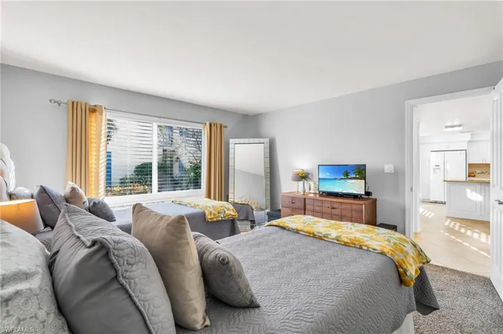 Tiled bedroom featuring white refrigerator with ice dispenser