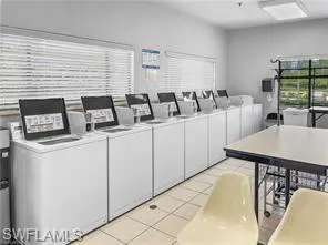 Clothes washing area featuring independent washer and dryer and light tile patterned flooring