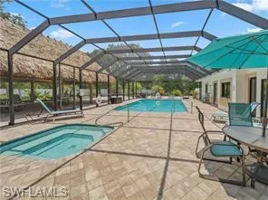 View of swimming pool with a patio area and glass enclosure