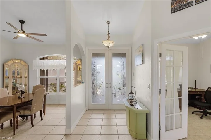 Tiled entryway with double glass front doors. and screened entryway for crossbreeze.