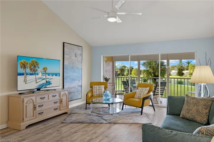 Living room featuring ceiling fan, high vaulted ceiling, and light hardwood / wood-style floors