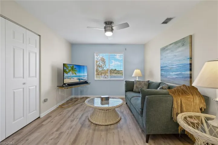 Living room with ceiling fan and light hardwood / wood-style floors