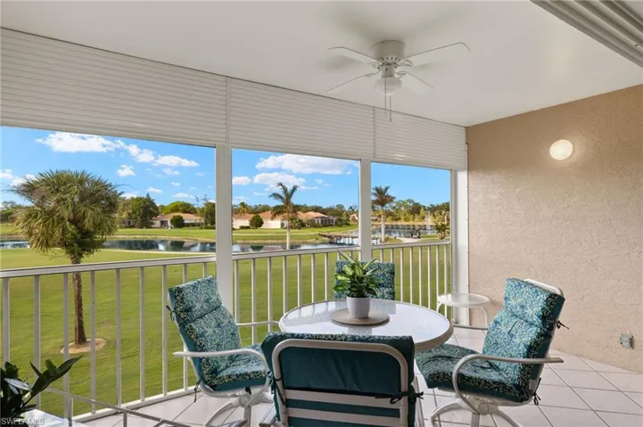 Sunroom / solarium featuring ceiling fan and a water view