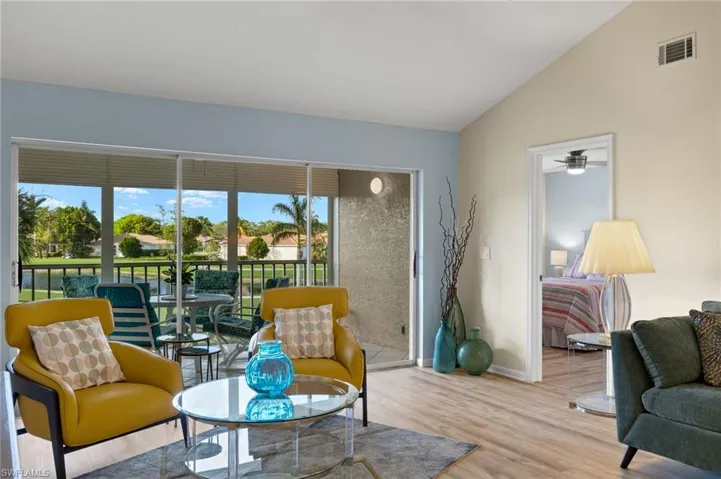 Sitting room with a wealth of natural light, ceiling fan, lofted ceiling, and hardwood / wood-style flooring