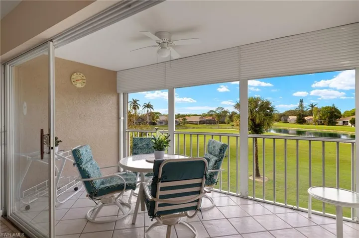 Sunroom / solarium with ceiling fan and a water view