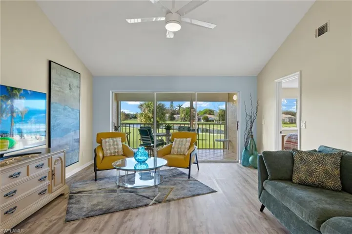 Living room featuring light hardwood / wood-style floors, high vaulted ceiling, and ceiling fan
