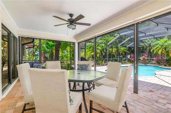Large entertainment area with a ceiling fan, outdoor dining area, and an outdoor pool