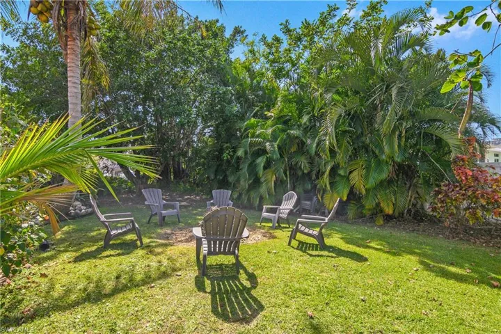 View of grassy yard with an outdoor fire pit