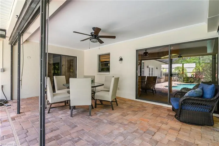 Large entertainment area with a ceiling fan, outdoor dining area, and an outdoor pool