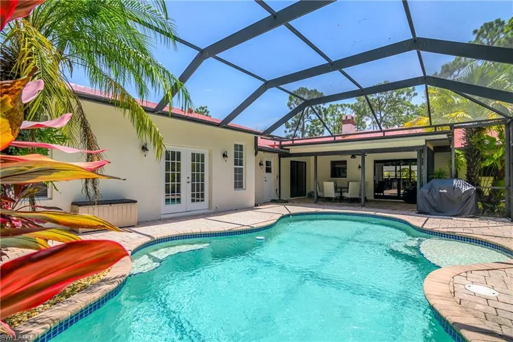 Swimming pool featuring french doors, a patio, grilling area, a ceiling fan, and a lanai