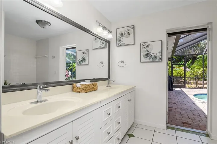 Full bathroom, freshly painted, with double vanity and tile patterned floors