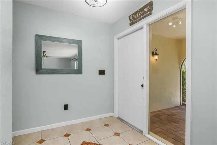 Entrance foyer with light tile patterned flooring and baseboards