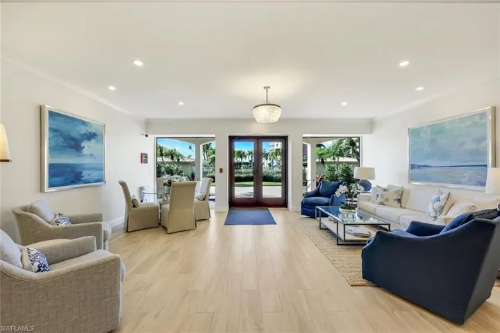 Living room featuring light wood-style floors, crown molding, french doors, and recessed lighting