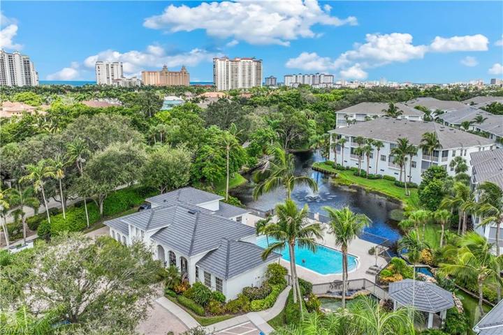 Aerial view of Breakwater at Pelican Bay overlooking clubhouse and amenities with Gulf of Mexico in the distance