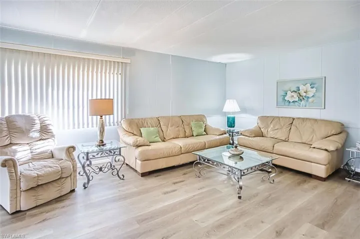 Living room featuring wood finished floors and a decorative wall
