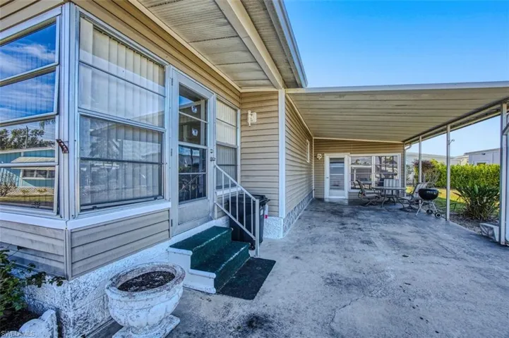 Property entrance with an attached carport and a patio area