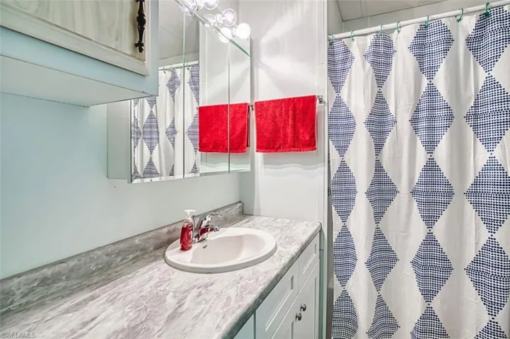 Full bath featuring vanity and curtained shower