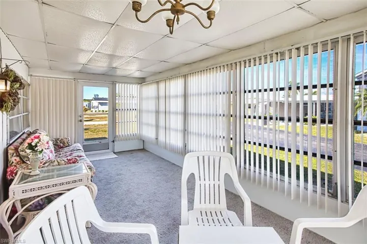 Sunroom / solarium featuring a chandelier