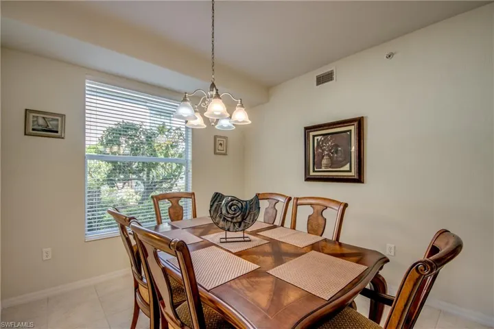 Dining space featuring light tile patterned flooring and an inviting chandelier