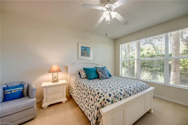 Bedroom with light colored carpet and ceiling fan