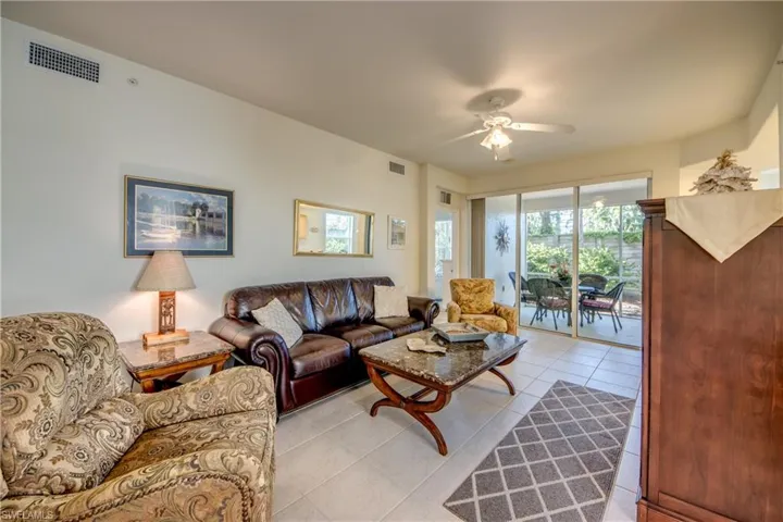 Living room with ceiling fan and light tile patterned floors