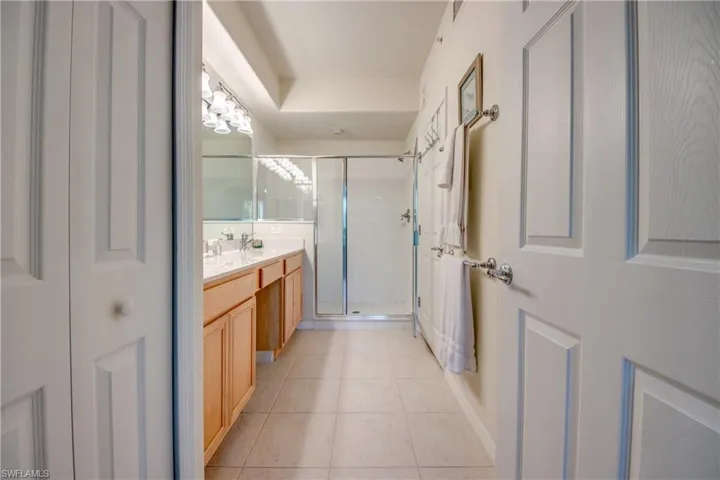 Bathroom with vanity, tile patterned flooring, and walk in shower