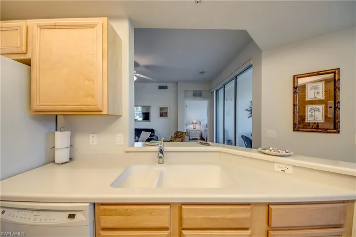 Kitchen featuring sink, dishwasher, ceiling fan, and light brown cabinets