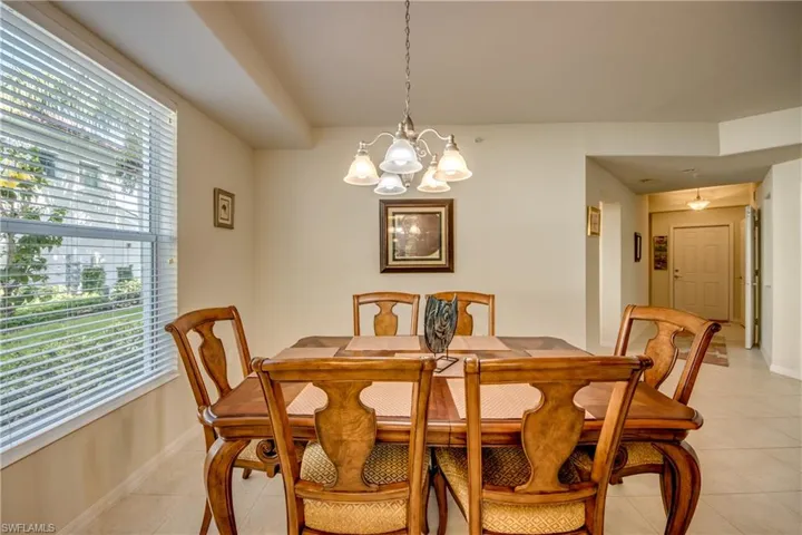 Dining space with plenty of natural light, a notable chandelier, and light tile patterned floors
