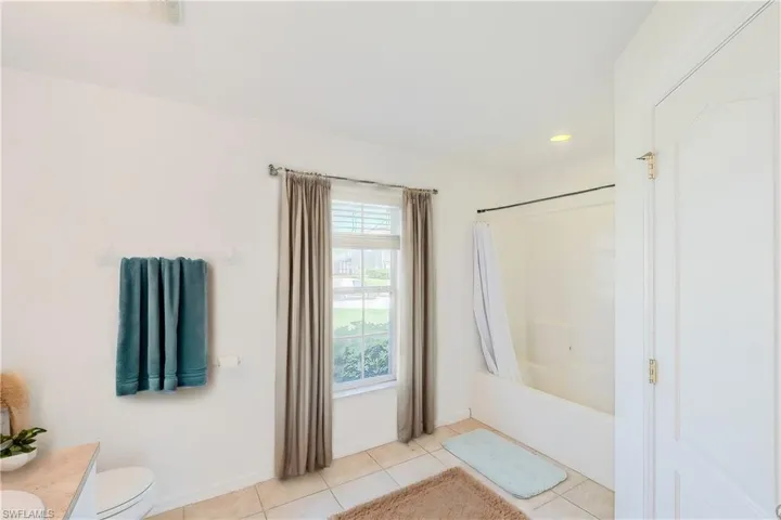 Full bathroom featuring toilet, shower / bathtub combination, tile patterned floors, and vanity (This photo was virtually staged)