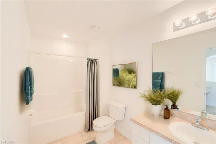 Full bathroom with toilet, vanity, shower / bath combo, and tile patterned floors(This photo was virtually staged)