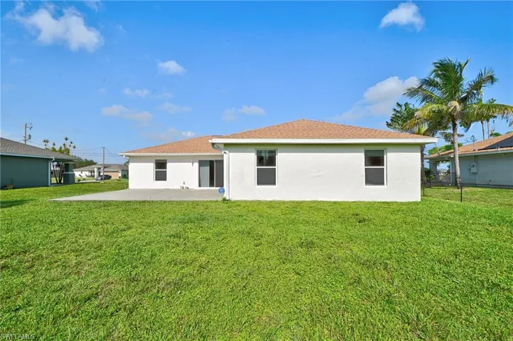Rear view of house featuring a lawn and a patio area