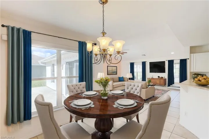 Tiled dining room with a notable chandelier (This photo was virtually staged)