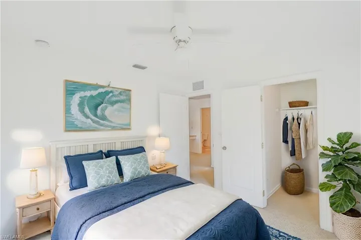 Carpeted bedroom with a walk in closet, a closet, and ceiling fan (This photo was virtually staged)