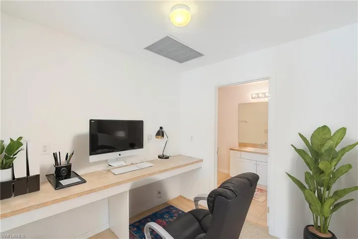 Carpeted office with built in desk and connecting bathroom (This photo was virtually staged)