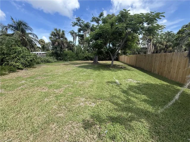 Expansive lot featuring mature trees, established lawn, and a privacy fence