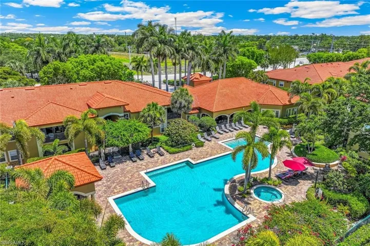 Community recreational area featuring a large, freeform swimming pool, an integrated spa, and an expansive paver patio