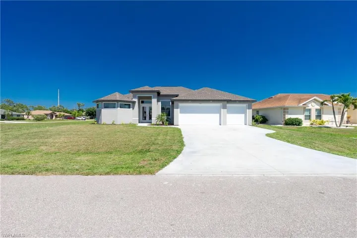 View of front of home featuring a garage and a front yard