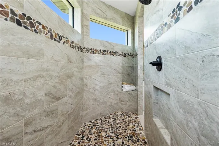Bathroom with tiled shower and plenty of natural light