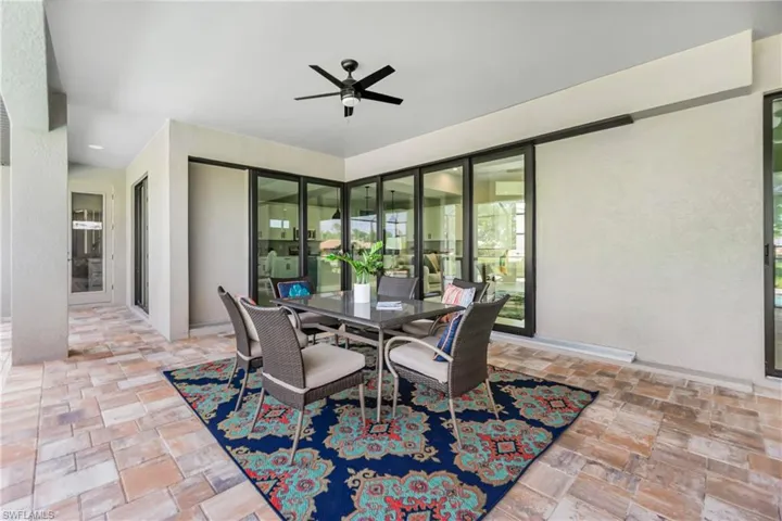 Dining area with ceiling fan and brick pavers.