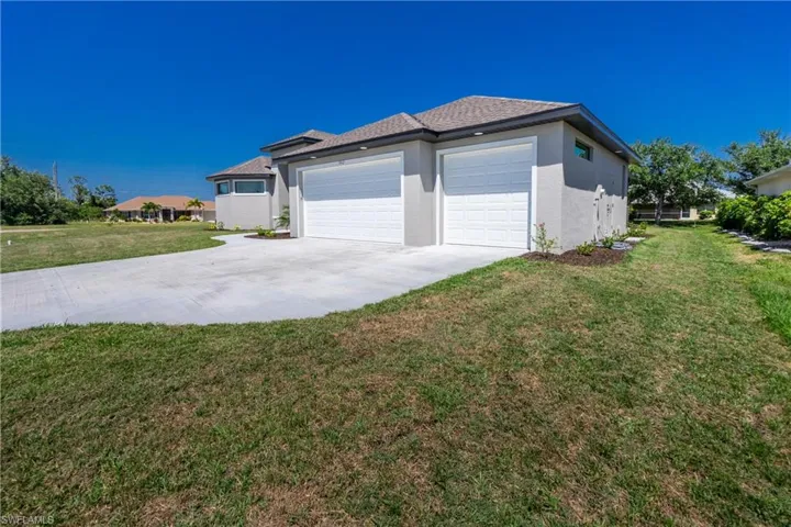 View of side of property featuring a yard and a garage