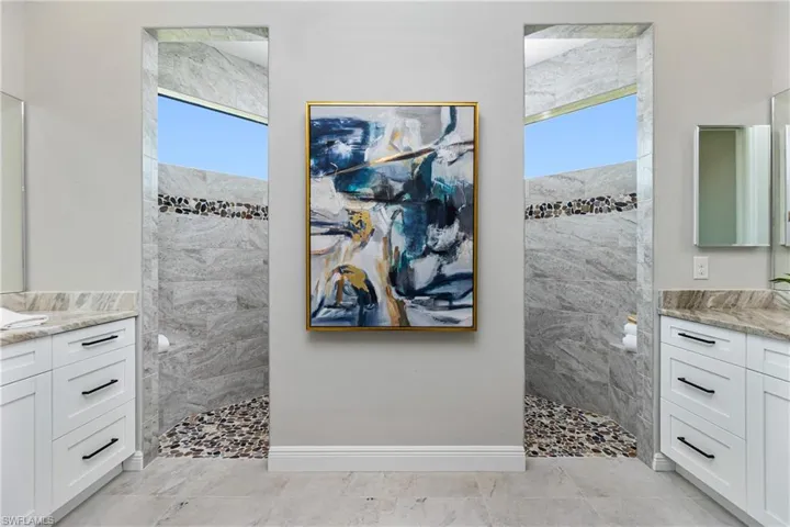 Main Bathroom with tile flooring, a wealth of natural light, and 2 vanities.