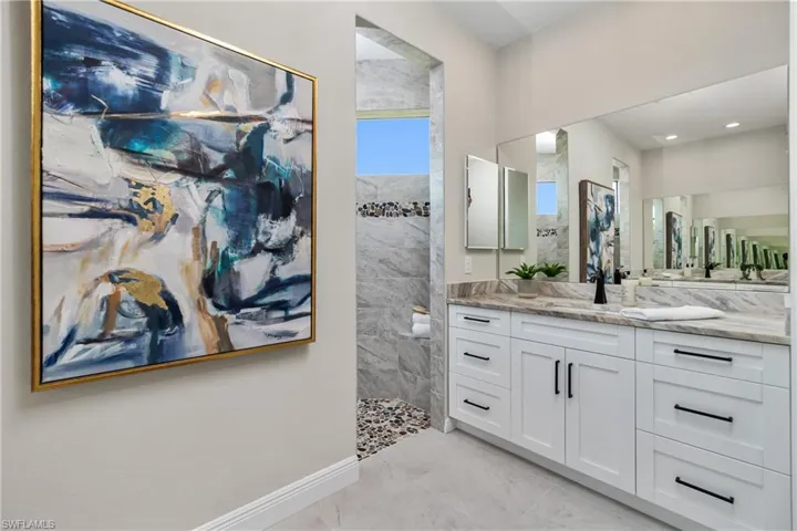 Bathroom featuring tiled shower, tile flooring, and vanity