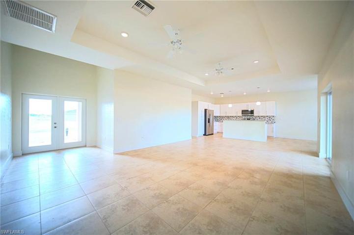 The Oversized Tiled Living Room Has A Tray Ceiling With Lights And Fans, Double Front Entry Doors, And A Double Slider That Leads Out To Covered Lanai!