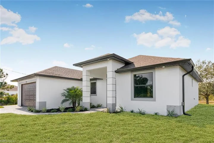 View of front of home featuring a garage and a front yard