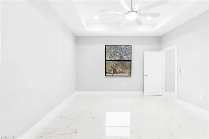 Empty room with a raised ceiling and ceiling fan