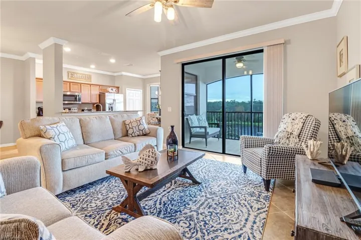 Tiled living room with ornamental molding and ceiling fan