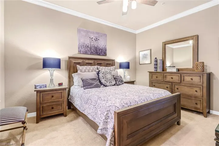 Bedroom featuring crown molding, light colored carpet, and ceiling fan