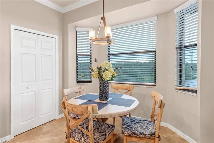 Dining area featuring light tile patterned floors, crown molding, and a chandelier