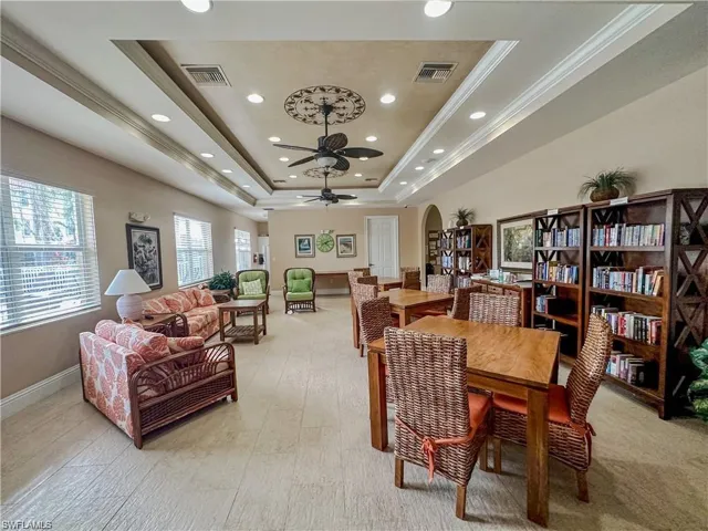 Dining room with ceiling fan, a raised ceiling, and crown molding