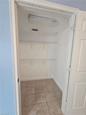 Walk in closet with light tile flooring